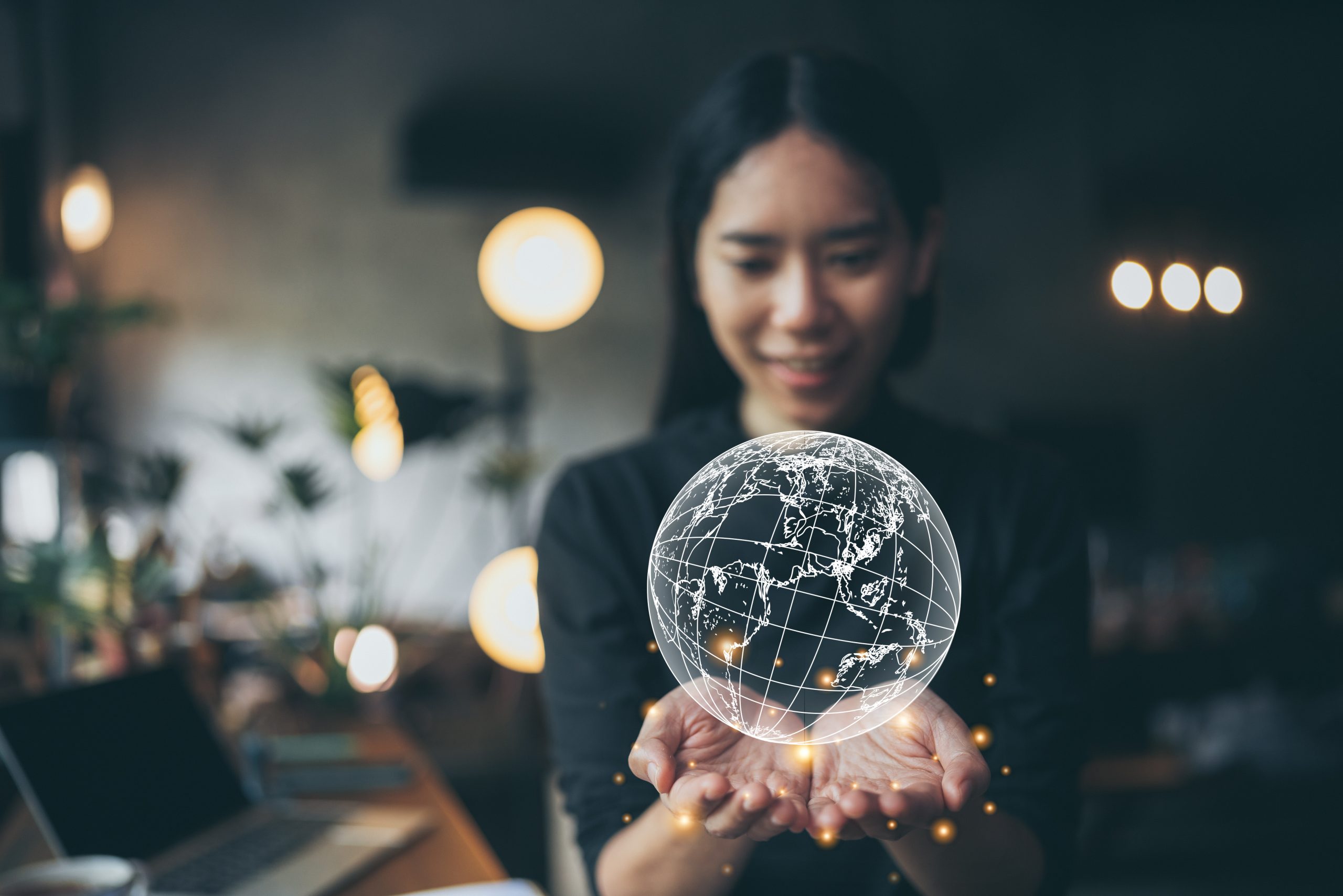 Businesswoman holding a glowing digital globe – representing global connectivity through a programmable SMS API