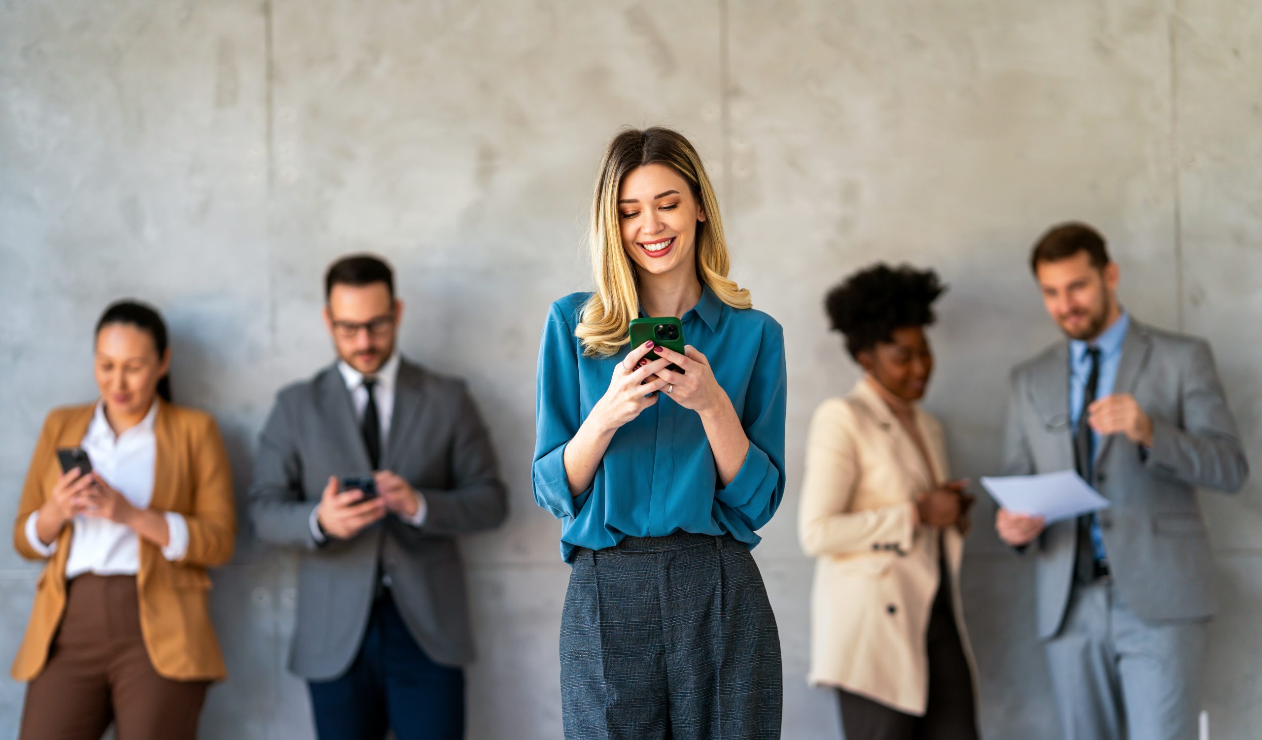 Smiling businesswoman using mobile phone powered by a Send SMS API for real-time customer messaging