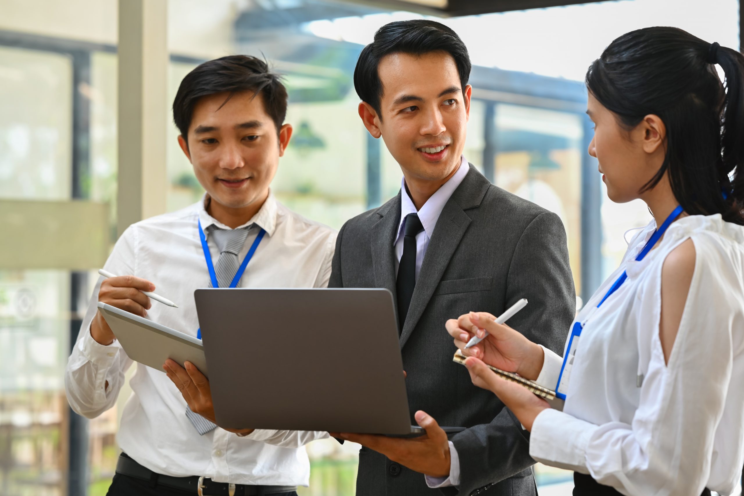 Business team discussing enterprise solutions with a laptop, representing the best SMS service provider for global enterprises.