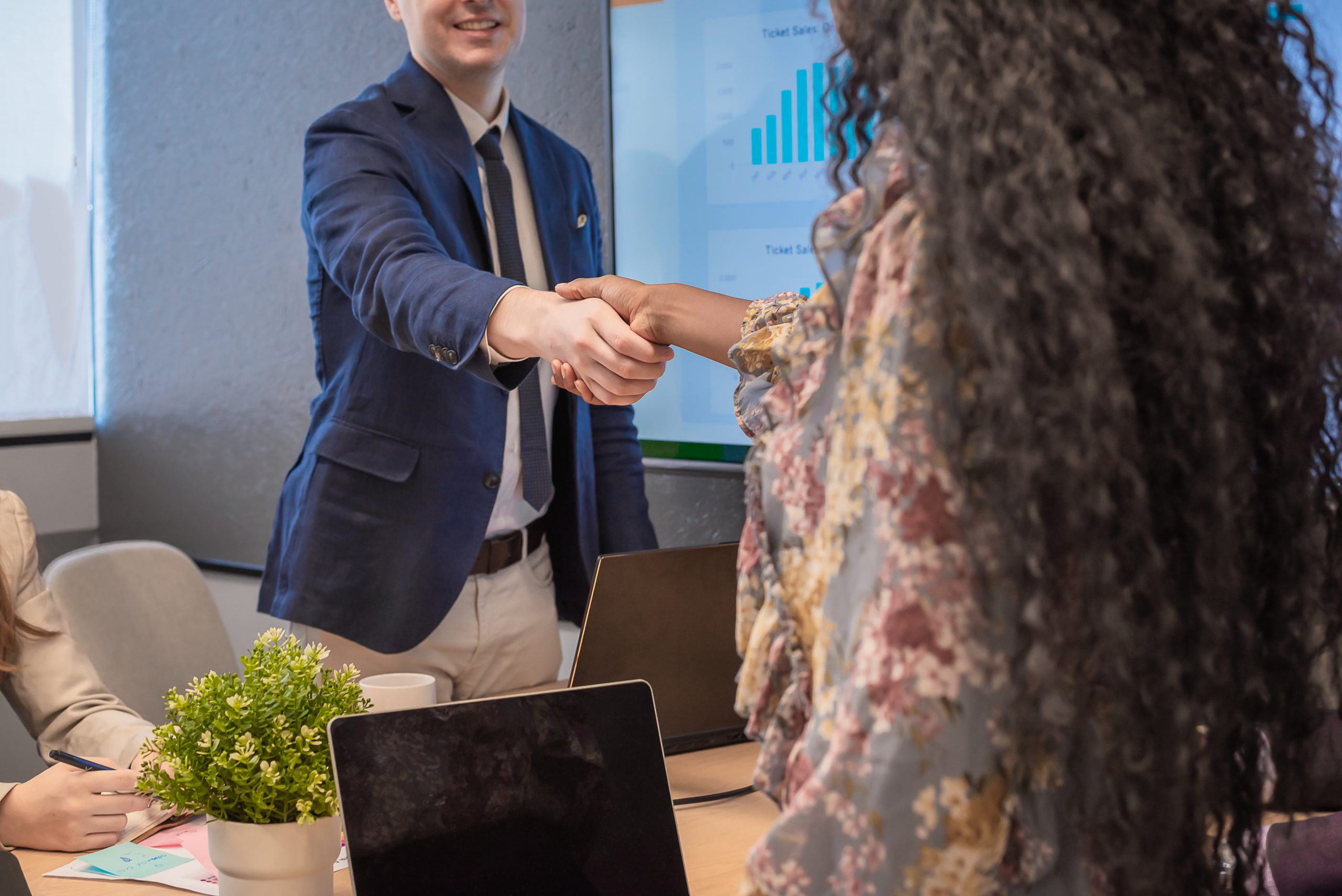 Business partners shaking hands after discussing customer retention strategies with Bulk SMS Malaysia