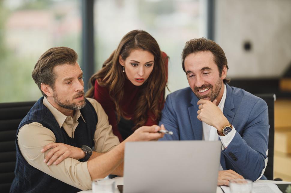 Business team reviewing analytics on desktop screens while evaluating the best SMS service provider for data-driven decisions