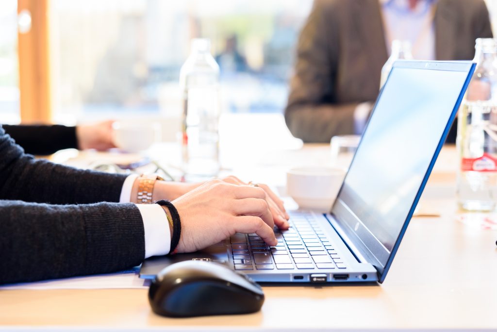 Business professional working on a laptop while evaluating an SMS Gateway Provider for reliable business messaging