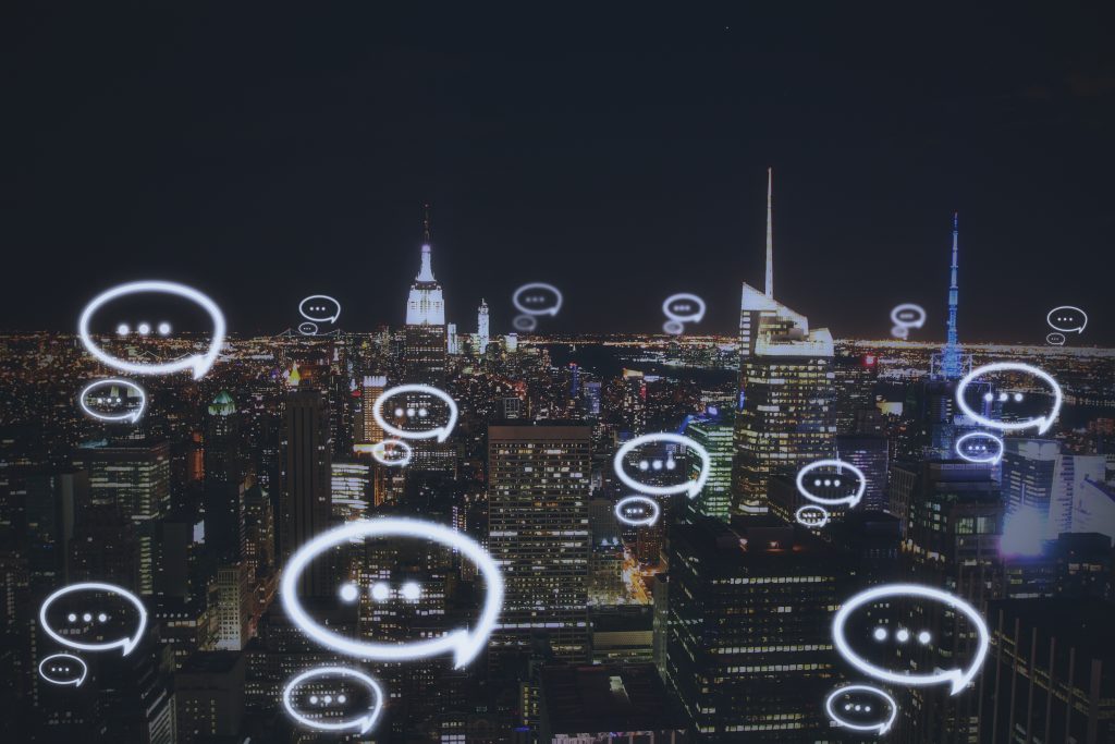 City skyline with chat message icons showing real-time global communication powered by a Messaging API