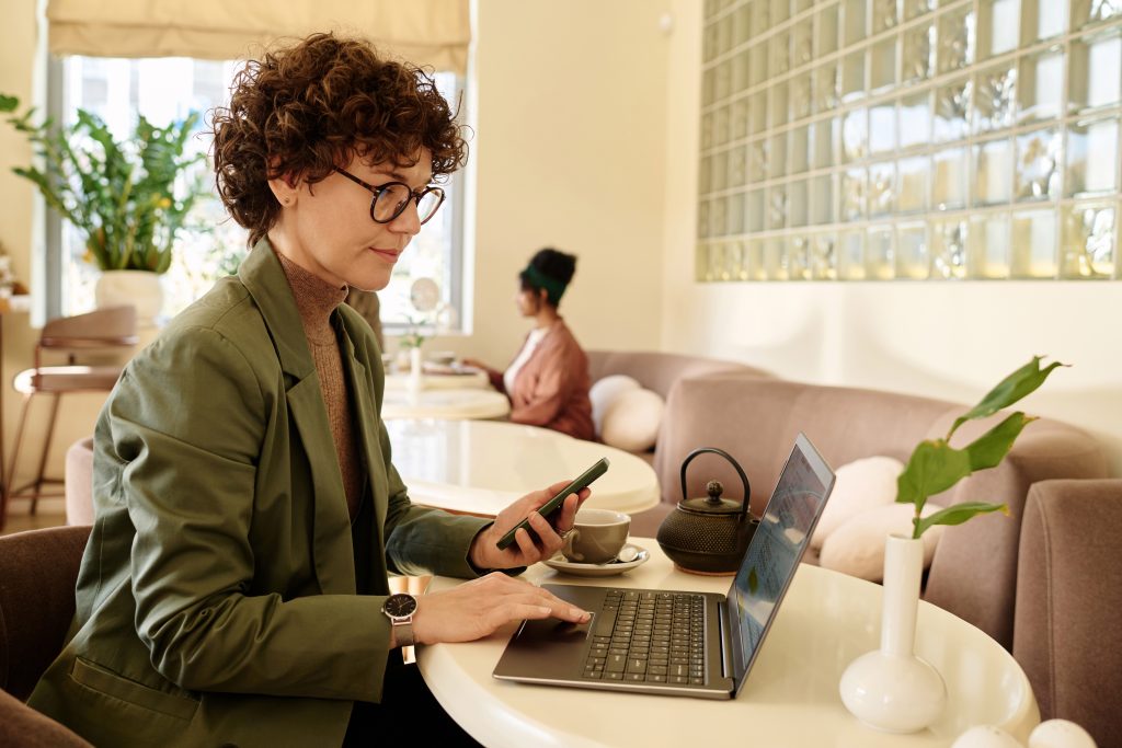 Professional working on laptop and smartphone while integrating a Messaging API into an existing platform