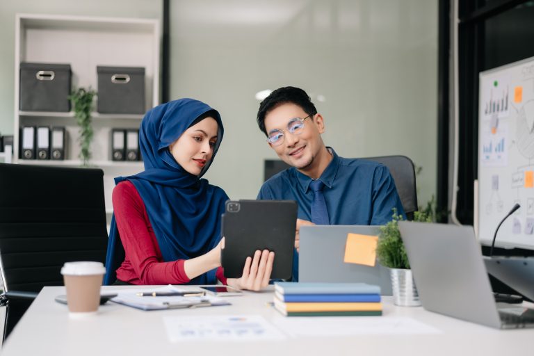 Business team reviewing tablet analytics for sms marketing malaysia Raya campaign planning in office