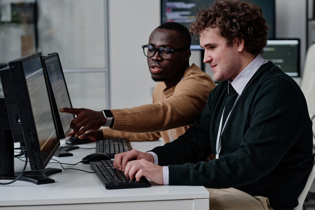 Developers reviewing code while integrating an SMS API from the best SMS service provider.