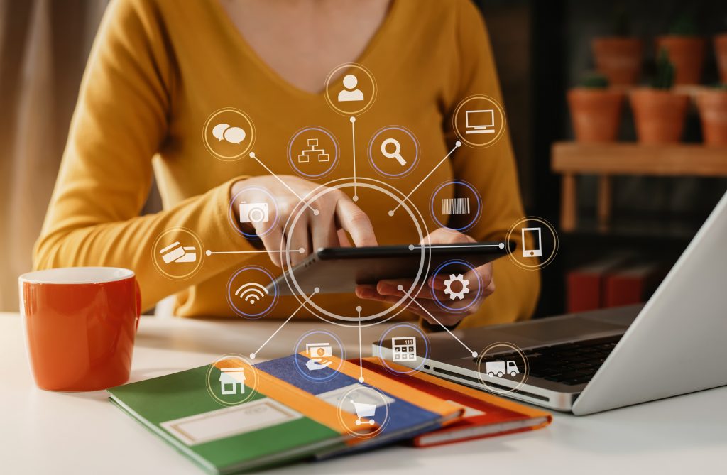A woman using a tablet with digital icons representing a Messaging API connecting omnichannel marketing channels.