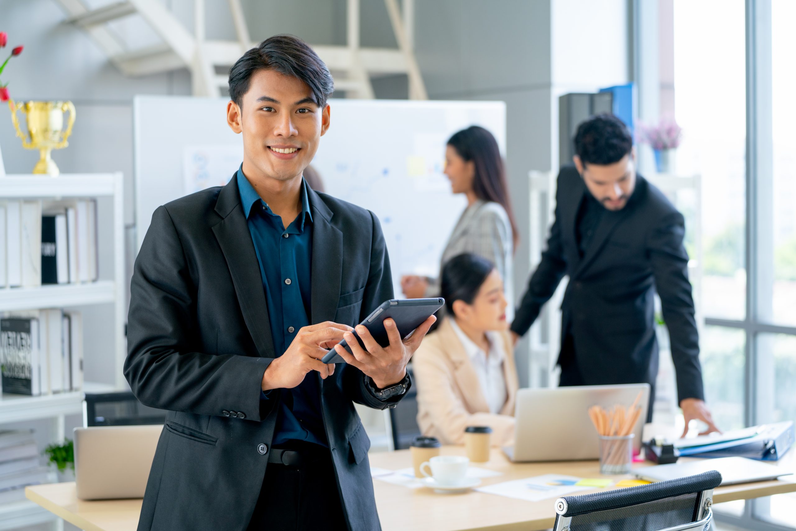 Business professional using tablet in office demonstrating sms service malaysia for customer communication