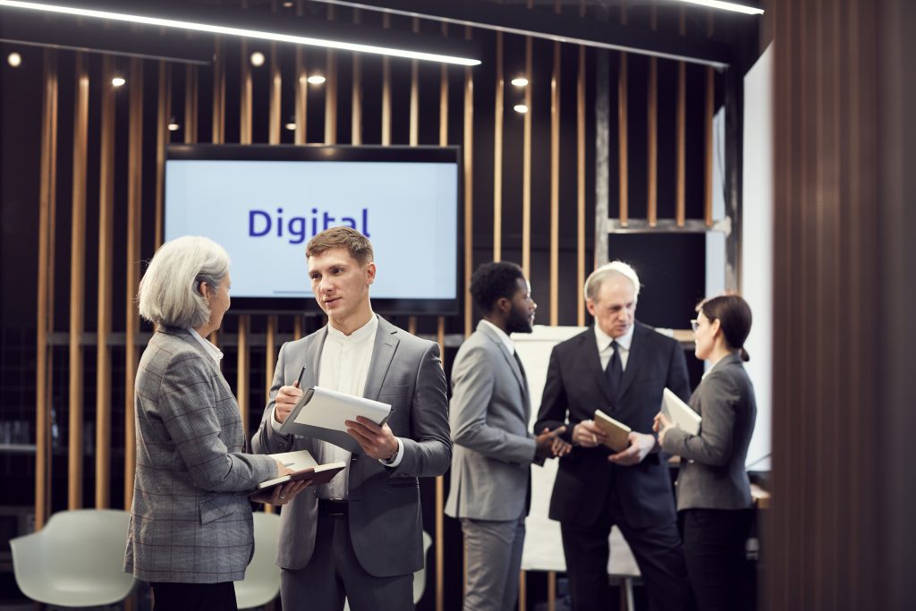 Business professionals discussing digital communication strategies and SMS Provider Malaysia solutions in a modern office