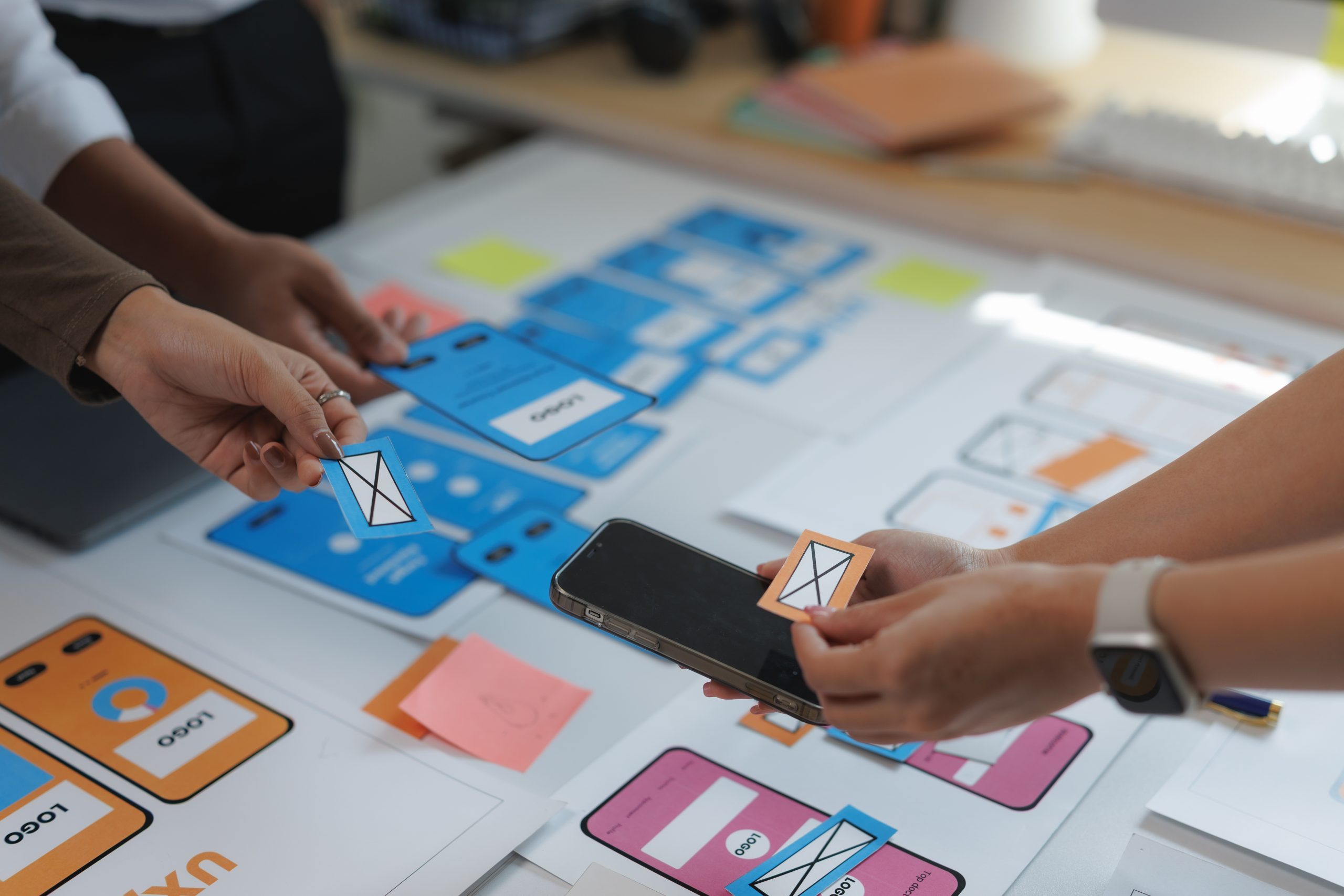 Messaging API security planning with a team reviewing mobile app wireframes and secure messaging workflows