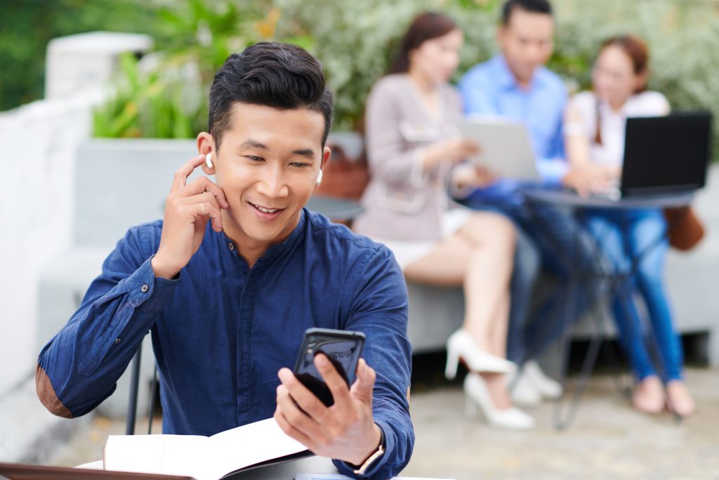 Business professional checking SMS notifications on a smartphone, illustrating modern SMS gateway provider communication trends.