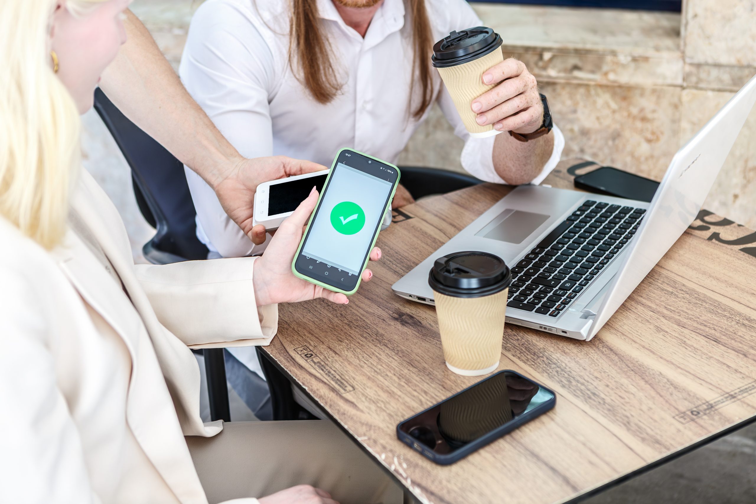 Business team reviewing WhatsApp Business API pricing on smartphones during a meeting.