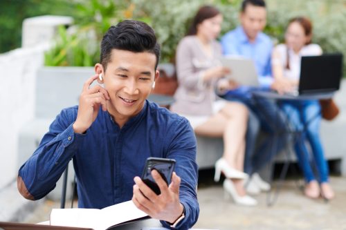 Business professional checking SMS notifications on a smartphone, illustrating modern SMS gateway provider communication trends.